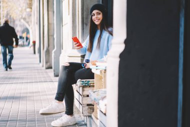 Şehirde boş zamanlarında hücresel cihazlar kullanan mutlu nesil Z, akıllı telefon teknolojisi olan neşeli kadın blogcu kendi yaşam tarzını ve çevrim içi ağ kurma zamanının keyfini çıkarıyor
