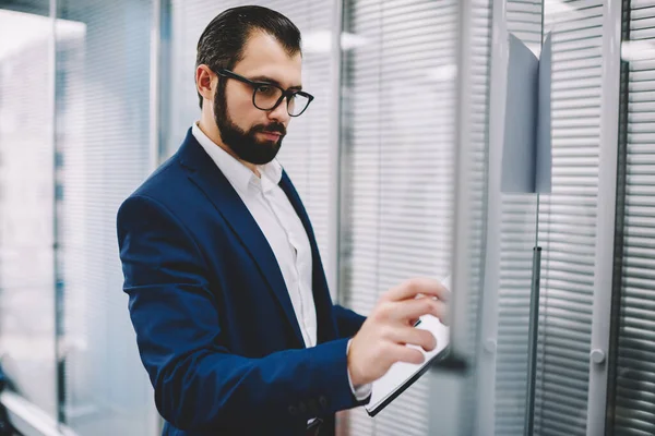 Concentrated Bearded Entrepreneur Elegant Suit Standing Documents Whiteboard Writing Information — Foto Stock