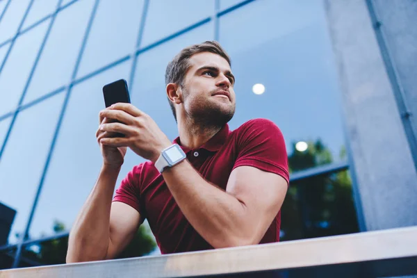 Smiling Young Man Casual Outfit Smartwatch Browsing Smartphone Looking Away — Foto de Stock