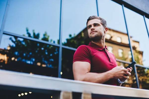 Pensive Young Hipster Polo Shirt Browsing Smartphone Looking Away Modern — Foto Stock