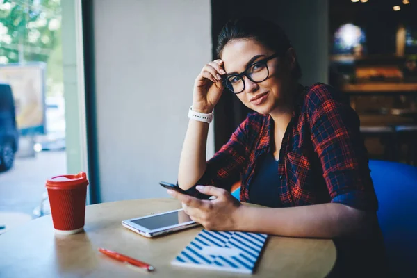 Alluring Ethnic Female Freelancer Trendy Outfit Eyeglasses Browsing Smartphone Looking — Zdjęcie stockowe