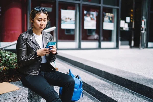Asian Hipster Girl Trendy Leather Jacket Using Cellphone Device Reading — Zdjęcie stockowe