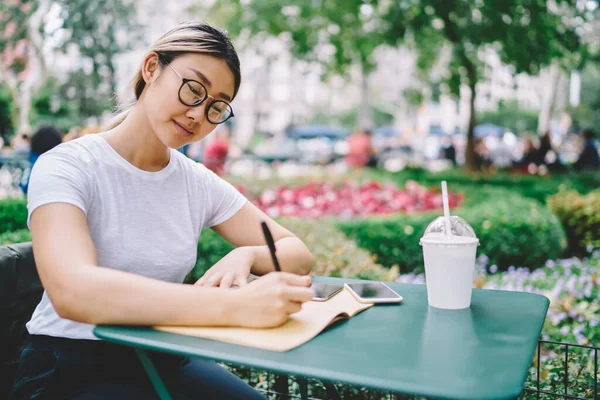 Asian Female Student Optical Spectacles Writing Memos Education Textbook Outdoors — Stockfoto