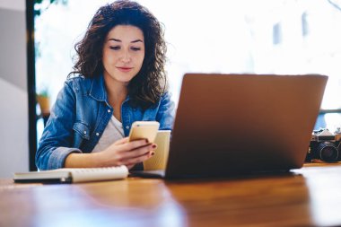Milenyum yeniyetme kız internet takipçileriyle birlikte çalışma alanındaki 4G internete bağlanan mesajlar, internet sitesi ve medya için modern cep telefonu ve dizüstü bilgisayar kullanan Kafkas blogcu