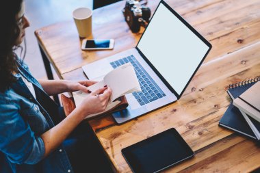 Sınav hazırlığı için çevrimiçi araştırma yapan bilgisayarlı yetenekli bayan öğrenci. Kopya alanı olan boş bir ağ kullanarak ders kitabı ile tanınamaz hale gelen serbest yazar.