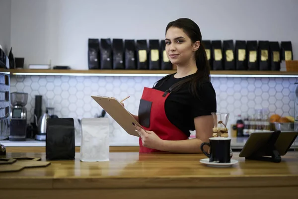 自信を持ってCaucasian女性バリスタプランナーは カフェテリアでバーに立って商業小売の監査を作ります 豊かな経験の女性のウェイトレスチェック注文プロのサービスを行う — ストック写真