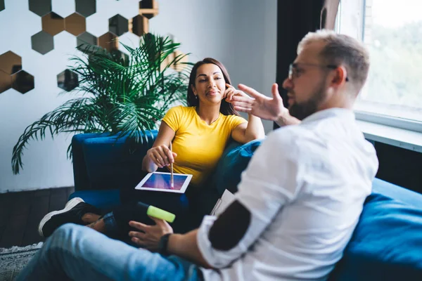 Thoughtful Diverse Coworkers Casual Outfits Sitting Comfortable Sofa Talking Each — стоковое фото