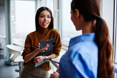 Caucaisan businesswoman in smart casual wear talking with employee about cooperation process making consultancy,professional female manager with reports discussing business plan with blurred colleague