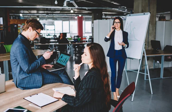 Multitasking process of professional experts using smartphones for messaging and calling during collaborative meeting for brainstorming on startup project and business planning, competitive people