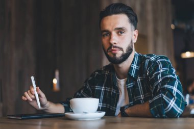 Kafkasyalı erkek gazetecinin portresi. Kafeteryada çay fincanı ile oturup kameraya baktığı için ders kitabı.