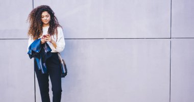 Sosyal medyada sohbet eden ve mesajlaşan genç bayan blogcu fotokopi alanı kentselliğinin yanında duruyor