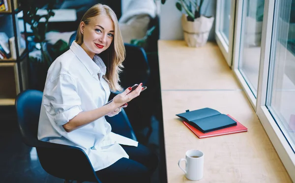 Sidovy Glad Ung Kvinna Vit Blus Sitter Vid Bordet Håller — Stockfoto