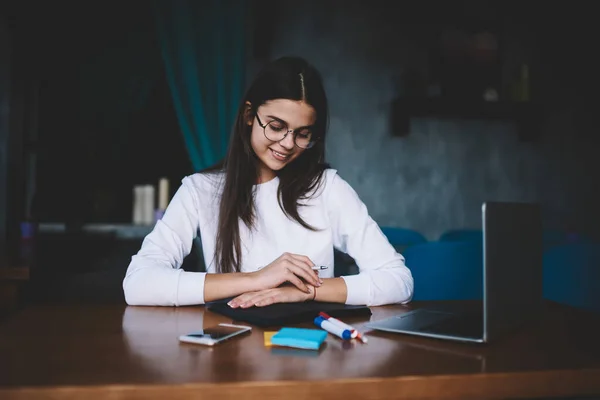 Delightful Young Freelancer Checking Written Information Planner While Sitting Wooden — Stockfoto