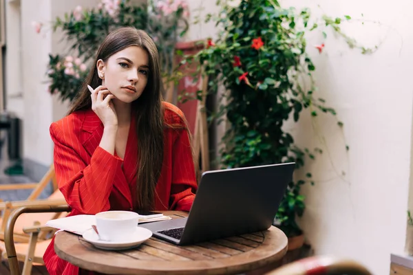 Joven Freelancer Femenina Hermoso Traje Rojo Con Bolígrafo Mano Sentada — Foto de Stock