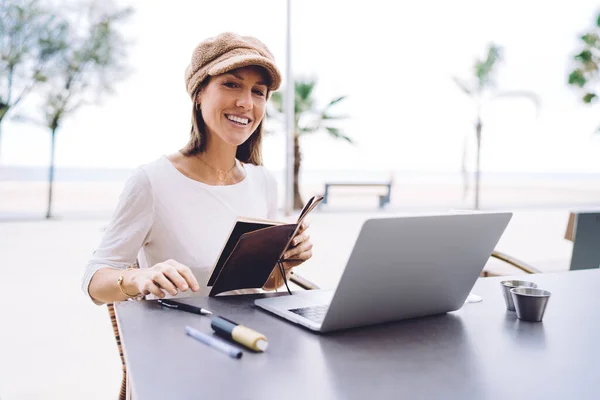 Happy Young Woman Trendy Outfit Smiling Camera Sitting Table Laptop — стоковое фото