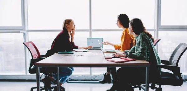 Vista Lateral Del Grupo Jóvenes Compañeras Sentadas Mesa Con Portátil —  Fotos de Stock