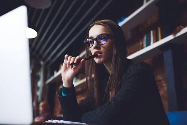 Low Angle Concentrated Female Freelancer Casual Outfit Eyeglasses Sitting Table — стоковое фото