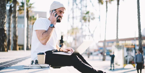 Cheerful Middle Eastern male freelancer smiling while making international consultancy conversation for discussing software developing