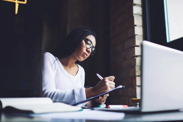 Serious African American Female Entrepreneur Writing Information Paper Clipboard While — стокове фото