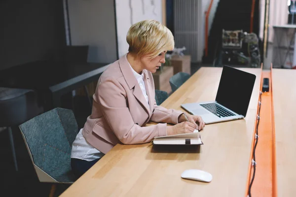 Side View Concentrated Businesswoman Formal Outfit Taking Notes Planner Sitting — 스톡 사진