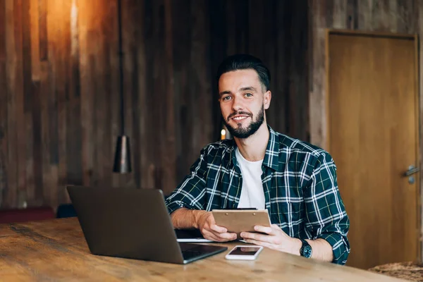 Başarılı erkek blogcu portresi. Sıradan giyiniyor. Planlama ve kameraya gülümseme için evrak tutuyor., 
