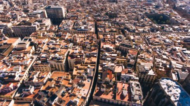 İspanya 'nın güneşli bir gününde Katalonya' da Avrupa şehrinin eski binalarının çatıları ve caddelerindeki evlerin havadan görünüşü