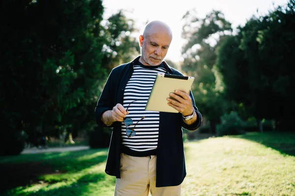 穿着休闲装的退休男子在触摸板上安装应用程序 用于网上聊天 — 图库照片