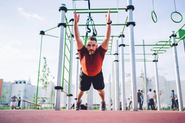 Vigorous Sportsman Raised Arms Doing Power Training While Hanging Straps — 图库照片