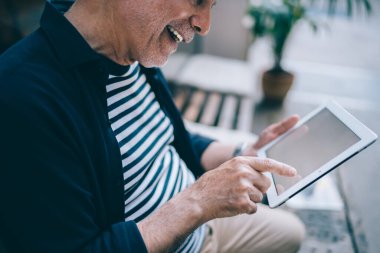 Kırpılmış neşeli blog yazarı, modern dokunmatik sayfada 4G kablosuz internet bağlantısı kullanarak ağ kurarken mutluluğu hissediyor