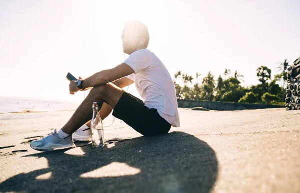 Visão Lateral Baixo Ângulo Atleta Masculino Pensativo Fones Ouvido Ouvindo — Fotografia de Stock