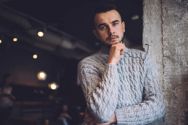 Melancholic Bearded Man Warm Knitted Sweater Holding Eyeglasses Touching Chin — Foto Stock