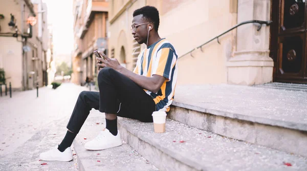 Πλευρική Άποψη African American Νεαρός Άνδρας Casual Φορούν Κάθεται Πέτρινα — Φωτογραφία Αρχείου