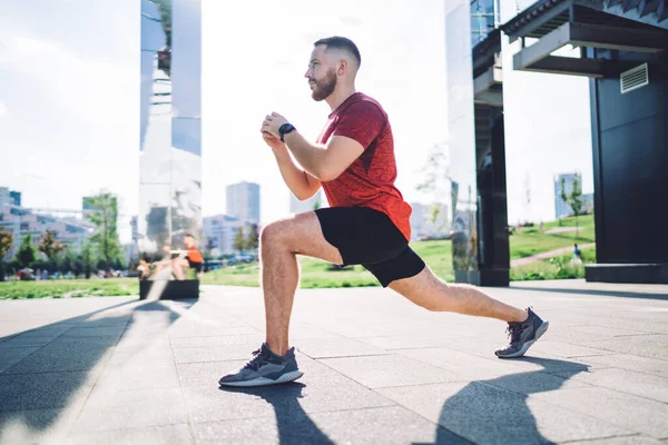 Spor ayakkabılı erkek sporcunun sabah erkenden bacaklarını esnerken bakışları ve ısınma hareketleri.