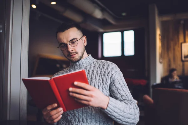 Skoncentrowany Brodaty Mężczyzna Ubraniach Casual Okularach Siedzi Fotelu Przytulnym Miejscu — Zdjęcie stockowe