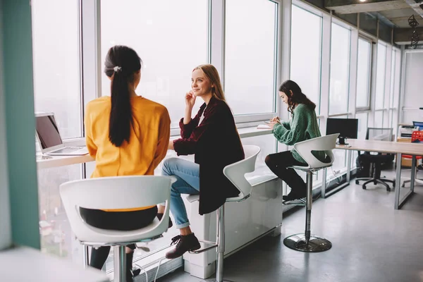 Jóvenes Amigas Con Atuendos Casuales Sentadas Mesa Cerca Ventana Panorámica —  Fotos de Stock