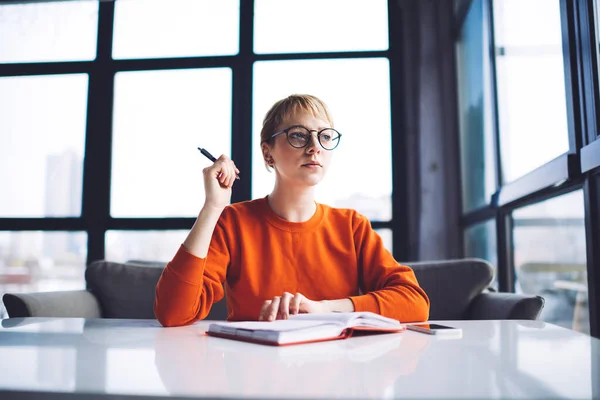 Joven Estudiante Rubia Concentrada Jersey Naranja Anteojos Escribiendo Ensayo Cuaderno — Foto de Stock