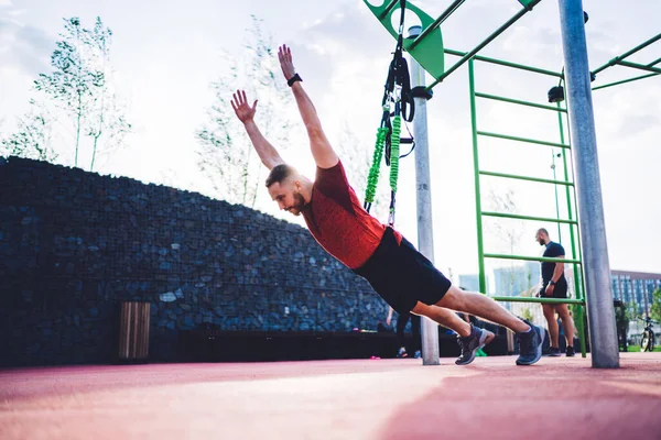 Low Angle Concentrated Male Athlete Hanging Parallel Ropes Intense Exercises — Stockfoto