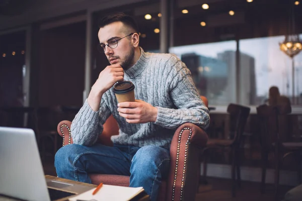 Koncentrerad Hane Glasögon Med Pappersmugg Varm Dryck Tittar Bärbar Dator — Stockfoto