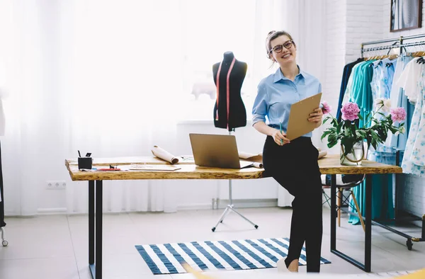 Lächelnde Näherin Mit Brille Und Klemmbrett Blickt Kamera Und Planung — Stockfoto