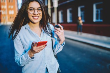 Akıllı telefonu ve kahve fincanı olan komik kadının yarısı güneşli yolculuk günlerinde boş vakit geçiriyor.