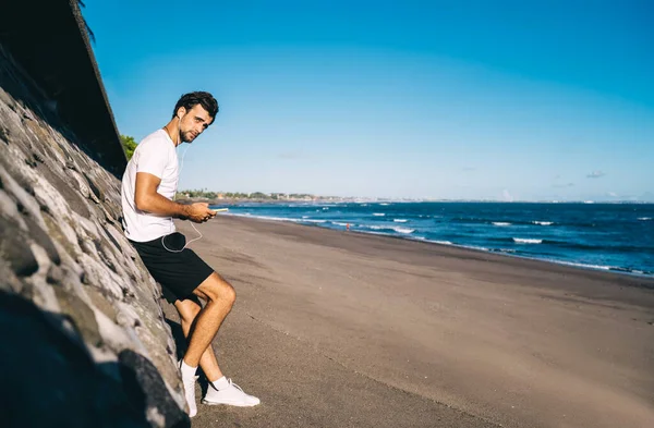 Serious Male Standing Wavy Sea Suny Summer Day Listening Music — Foto Stock