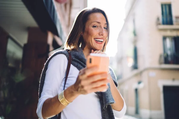 Delighted Adult Female Traveler Casual Clothes Smiling Taking Selfie Smartphone – stockfoto