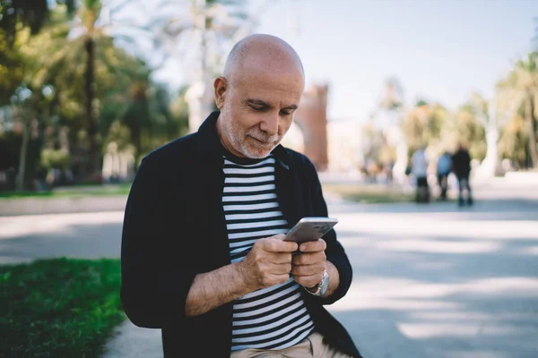Aged male tourist connecting to 4g in roaming for using cellular application and make online booking