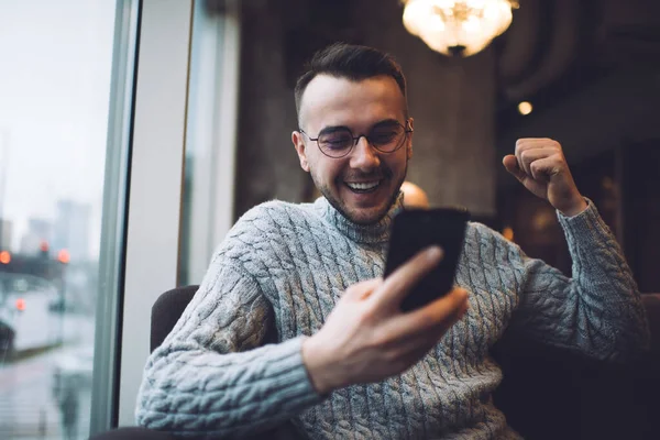 Homem Barbudo Otimista Roupa Casual Óculos Sorrindo Mensagens Smartphone Enquanto — Fotografia de Stock