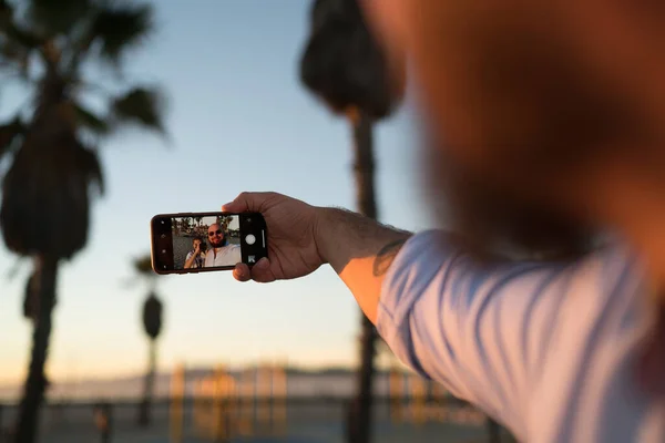 Güneş Gözlüklü Sakallı Erkek Turist Akşamları Sokakta Dikilirken Cep Telefonuyla — Stok fotoğraf