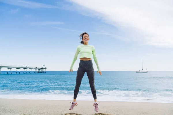 Chica Forma Despreocupada Saltando Playa Arena Sonriendo Cámara Durante Entrenamiento — Foto de Stock