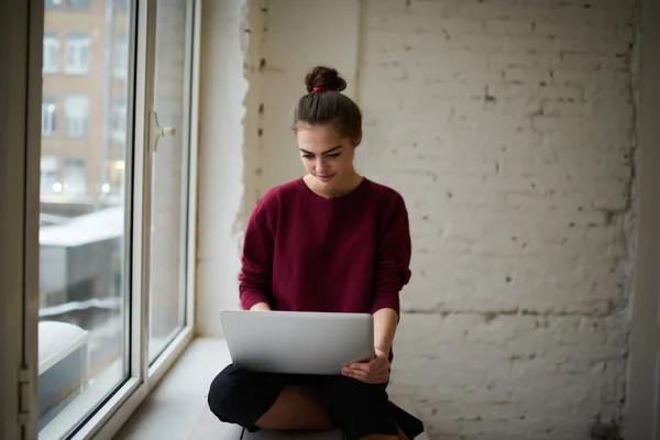 Concentrated Female Freelancer Casual Clothes Sitting Windowsill Using Laptop Working — Fotografia de Stock