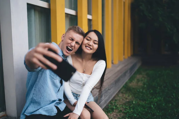 Pareja Étnica Positiva Traje Casual Sentada Banco Tomando Fotos Mientras —  Fotos de Stock