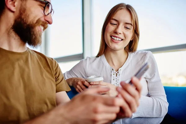 幸せな男性と女性の友人は モバイルガジェット上のアプリケーションを介してソーシャルメディアでブログをしながら通信します — ストック写真