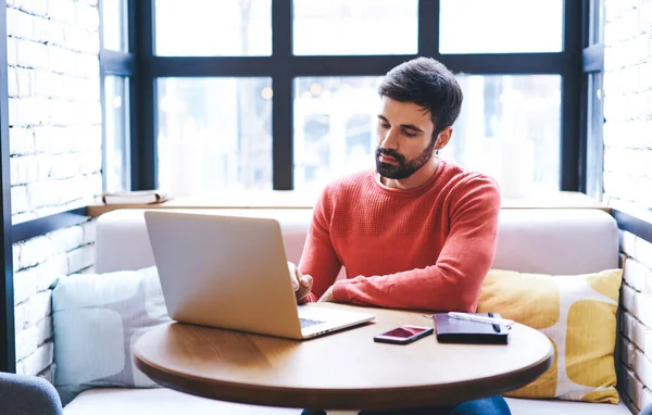 Geconcentreerde Freelancer Met Baard Met Behulp Van Netbook Kijken Naar — Stockfoto